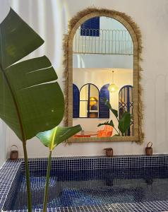 a bathroom with a mirror and a plant at Riad Lyabaïana privatisé, piscine et vue mer dans la médina in Tangier