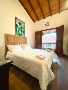 a bedroom with a large white bed with a clock on the wall at Hotel Monte verde in Salento