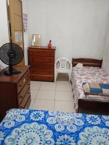 a bedroom with two beds and a dresser and a chair at Casa a 5 minutos da Sede da COP30 in Belém