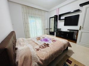 a bedroom with a bed with a blanket on it at Dream Appartement Monastir in Monastir +3 photos