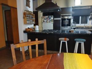 a kitchen with a table and two stools in it at Dejavú in San Marcos Sierras +17 photos
