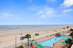 a view of a beach with a swimming pool and the ocean at Direct Oceanfront 1BR Balcony King Bed Beach Access in Daytona Beach