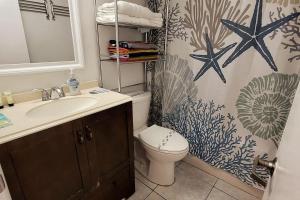a bathroom with a sink and a toilet with a starfish wallpaper at WHAT A VIEW!!!! Full Oceanview, Kitchen, King Bed in Daytona Beach +28 photos