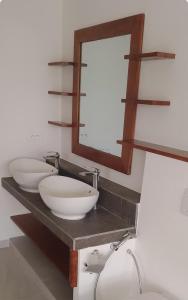 a bathroom with two white sinks and a mirror at Villa d'évasion proche de la plage in Boukot Ouolof