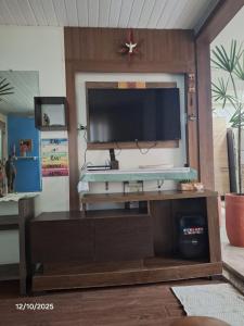 a living room with a tv on a wooden entertainment center at Recanto Morada Amazônica in Manaus