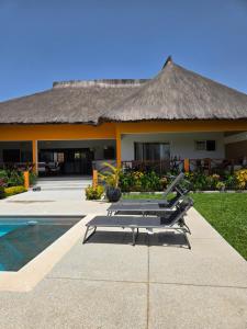 a resort with two lounge chairs and a swimming pool at Villa d'évasion proche de la plage in Boukot Ouolof