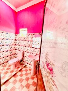 a pink bathroom with a toilet and a sink at White Palace airport hotel in Katunayake