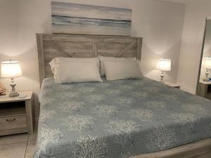 a bedroom with a large bed with two lamps at WHAT A VIEW!!!! Full Oceanview, Kitchen, King Bed in Daytona Beach