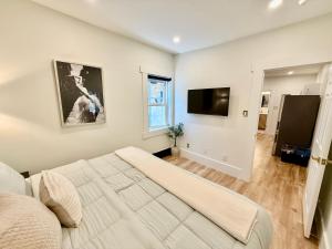 a bedroom with a large bed and a flat screen tv at Kiari Suites on Main in Moncton