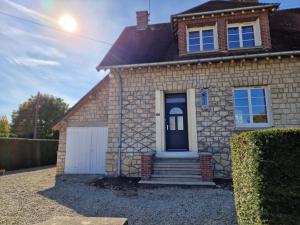 una casa di mattoni con una porta blu e un garage di Hildegarde's Friend a Brienne-le-Château