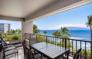 a balcony with a table and chairs and the ocean at Kaanapali Alii 2 Bedroom Oceanfront in Kaanapali