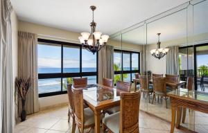 a dining room with a table and chairs and large windows at Kaanapali Alii 2 Bedroom Oceanfront in Kaanapali