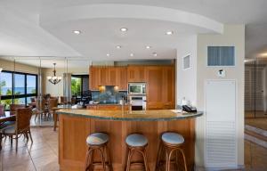 a kitchen with a island with bar stools at Kaanapali Alii 2 Bedroom Oceanfront in Kaanapali +62 photos
