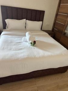 a white bed with a bouquet of flowers on it at Casa de Marinero in Martil