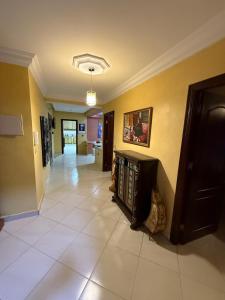 Una sala de estar con suelo de baldosas y paredes amarillas en Appartement Jihan, en Tánger