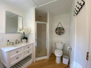a white bathroom with a toilet and a sink at Red Roof Cabin - Suite  +35 photos