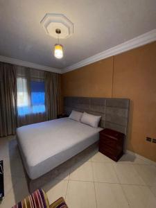 Un dormitorio con una cama grande y una ventana. en Appartement Jihan, en Tánger