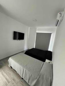 ein Schlafzimmer mit einem Bett und einem Flachbildfernseher in der Unterkunft Torres Al Mar in Monte Hermoso