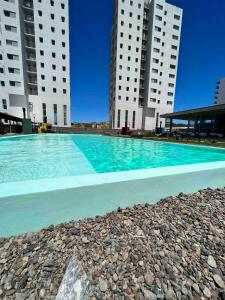 ein Swimmingpool vor zwei hohen Gebäuden in der Unterkunft Torres Al Mar in Monte Hermoso
