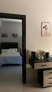a bedroom with a bed and a table with a mirror at استديو هادئ وأنيق بتصميم عصري in Al Kharj