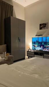 a bedroom with a large bed and a large screen tv at استديو هادئ وأنيق بتصميم عصري in Al Kharj