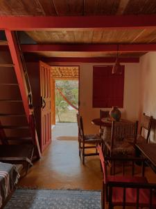 a dining room with a table and chairs and a door at Casa Vulva Caraíva l Hostel feminino com vibe de lar in Caraíva