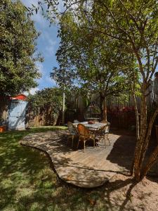 a patio with a table and chairs in a yard at Casa Vulva Caraíva l Hostel feminino com vibe de lar in Caraíva