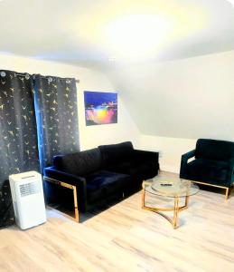 - un salon avec un canapé noir et une table en verre dans l'établissement New & Chic 5 min walk to falls, à Niagara Falls