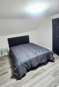 - une chambre avec un lit et une couette noire dans l'établissement New & Chic 5 min walk to falls, à Niagara Falls