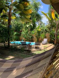 uitzicht op een zwembad met 2 stoelen en een tafel bij Casa Baleia in Itacaré