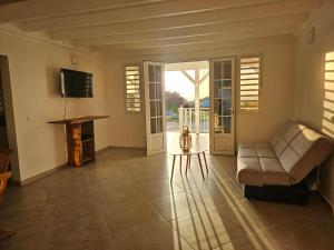 a living room with a couch and a television at Villa indigo Gp in Vieux-Habitants