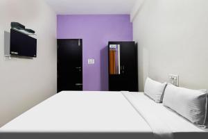 BelagulaHotel O MK Arcade的一间卧室，里面有一张大床和两个黑色橱柜。