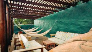 a hammock and a couch on a patio at Viajero Bacalar Hostel in Bacalar