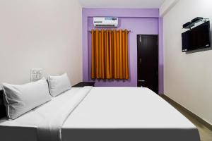 BelagulaHotel O MK Arcade的一间带大床和电视的卧室