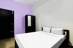 BelagulaHotel O MK Arcade的卧室配有白色的床和紫色的墙壁 更多29张照片