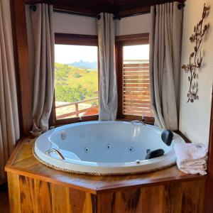 een groot bad in een kamer met een raam bij Chalés Água azul in Santo Antônio do Pinhal +220 foto's