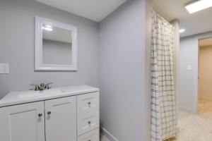 a white bathroom with a sink and a mirror at Ski, Hike and Explore Home 5 Mi to Dtwn Burlington! in Essex Junction +16 photos