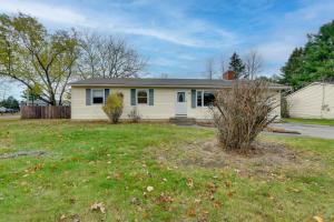 a white house with a yard with a house at 15 Mi to Cochrans Ski Area Cozy Home with Yard! in Essex Junction