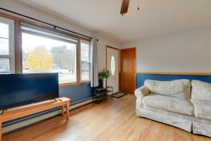 a living room with a couch and a large window at 15 Mi to Cochrans Ski Area Cozy Home with Yard! in Essex Junction