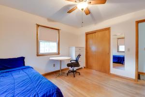a bedroom with a bed and a desk and a table at 15 Mi to Cochrans Ski Area Cozy Home with Yard! in Essex Junction