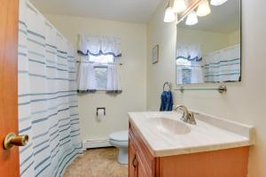 a bathroom with a sink and a toilet and a mirror at 15 Mi to Cochrans Ski Area Cozy Home with Yard! in Essex Junction +16 photos