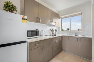 ジーロングにあるNewly Renovated Geelong Serviced Apartments by Short & Long Staysの冷蔵庫と電子レンジ付きのキッチン