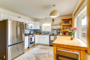 a kitchen with white cabinets and a stainless steel refrigerator at 12 Mi to Bozeman Pet-Friendly Gem with Sauna and Yard in Belgrade +26 photos