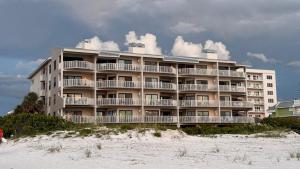 un grand immeuble situé sur la plage, à côté du sable dans l'établissement Clearwater Vista, à Clearwater Beach