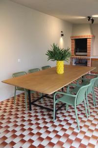 einem Esstisch mit Stühlen und einer Topfpflanze in der Unterkunft SixtyNine Beach Cottage in Torreira + 57 Fotos