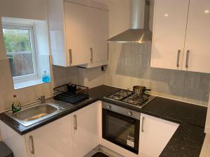 a kitchen with a sink and a stove at Cosy Home Cardiff in Cardiff +9 photos