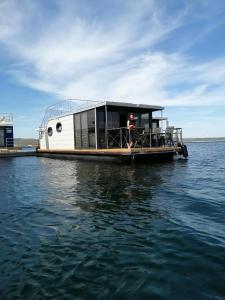 Un homme est debout sur un bateau dans l'eau dans l'établissement Hausboot Mit Sauna, à Braunsbedra