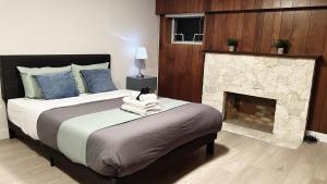 - une chambre avec un grand lit et une cheminée dans l'établissement Spacious Private Family Room in Homestay, à Vancouver