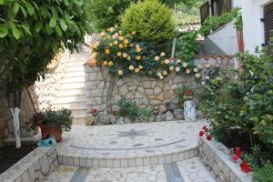 a garden with flowers and a stone wall at Villa Sojat in Crikvenica