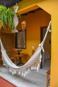 a hammock hanging in a room with a table at Pousada João Maria in Trancoso